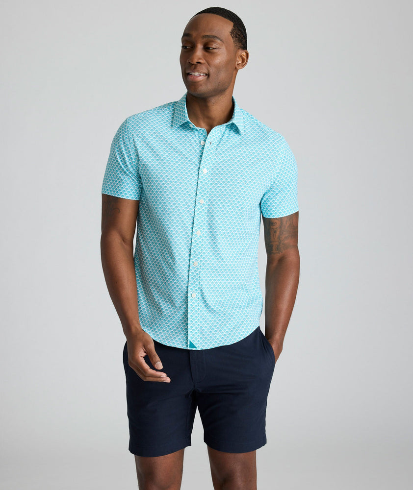 Model is wearing UNTUCKit Abbott performance print short sleeve shirt in teal.