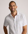 Model is wearing UNTUCKit Dixon short sleeve shirt with white grounded Dimond print.