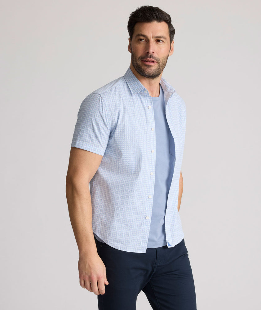 Model is wearing UNTUCKit Dunbar short sleeve shirt in blue and white Dimond print.