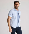 Model is wearing UNTUCKit Dunbar short sleeve shirt in blue and white Dimond print.