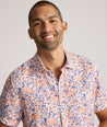 Model is wearing UNTUCKit Ellsworth Short Sleeve shirt in orange and blue floral.