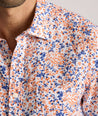 Model is wearing UNTUCKit Ellsworth Short Sleeve shirt in orange and blue floral.