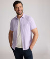 Model is wearing UNTUCKit Gironde short sleeve performance  shirt in purple.
