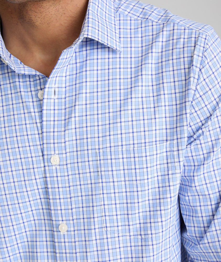 Model is wearing UNTUCKit Kaleb long sleeve performance shirt in light blue and white check.
