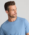 Model is wearing UNTUCKit saxum Ultra Soft tee in soft blue.