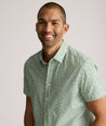 Model is wearing UNTUCKit Yorke performance short sleeve green and yellow floral print shirt.