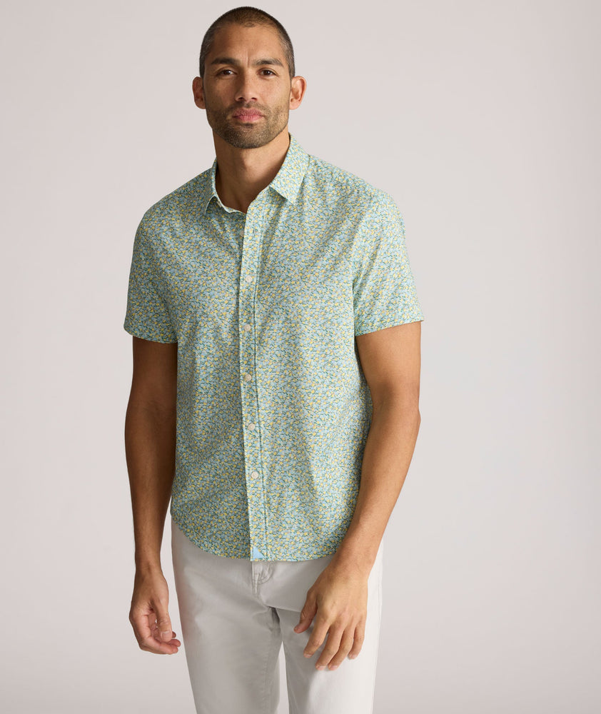 Model is wearing UNTUCKit Yorke performance short sleeve green and yellow floral print shirt.