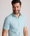Model is wearing UNTUCKit Ackerman shirt in green ditsy floral print. 