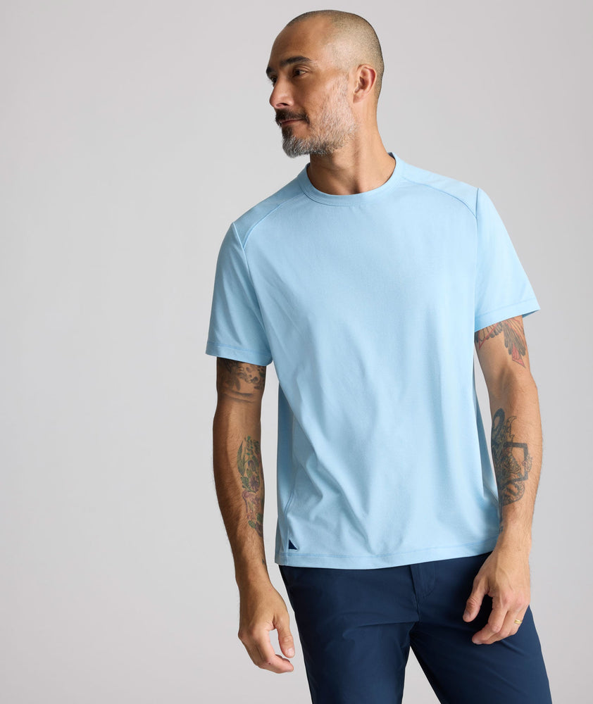 Model is wearing UNTUCKit Performance Tee in light blue. 