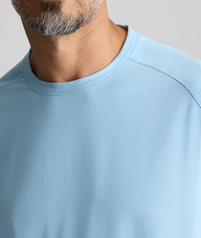 Model is wearing UNTUCKit Performance Tee in light blue. 