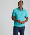 Model is wearing UNTUCKit Performance Polo in teal. 