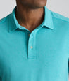 Model is wearing UNTUCKit Performance Polo in teal. 