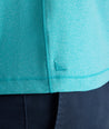 Model is wearing UNTUCKit Performance Polo in teal. 