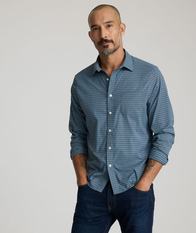 Model is wearing UNTUCKit Delune performance shirt in green check. 