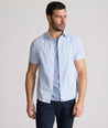 Model is wearing UNTUCKit Dunbar short sleeve shirt in blue and white Dimond print. 