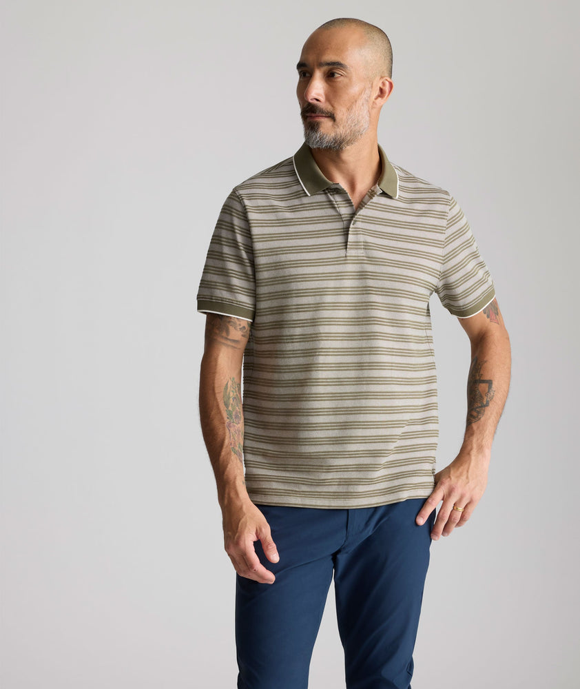 Model is wearing UNTUCKit Performance Hybrid Polo in dark green. 