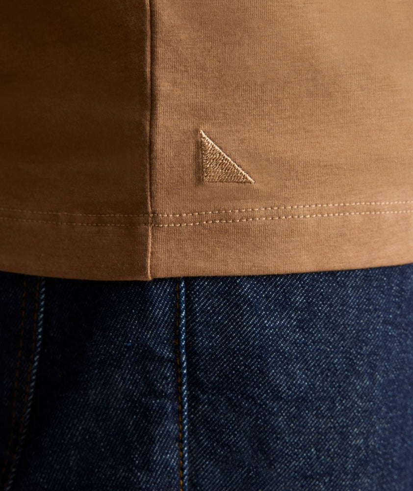 Model is wearing UNTUCKit EcoSoft Short-Sleeve Henley in toasted coconut. 
