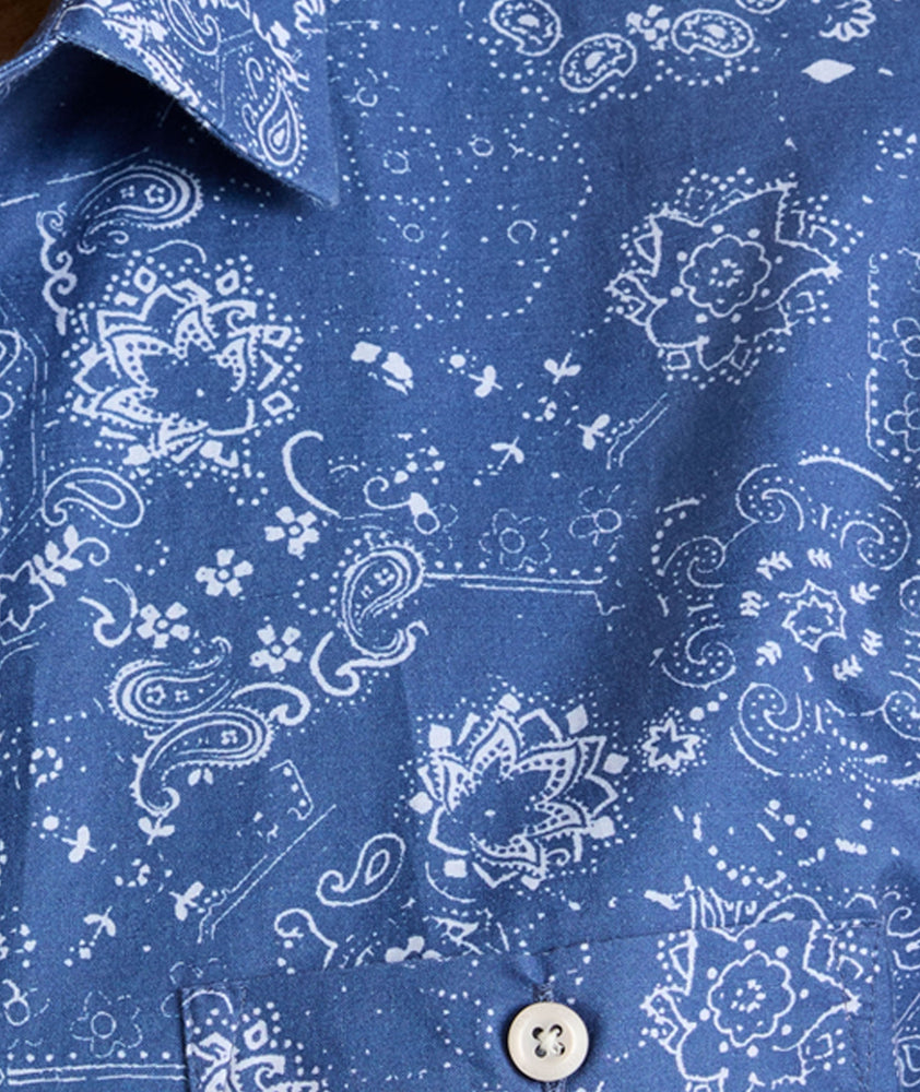 Model is wearing UNTUCKit Monroe cotton linen short sleeve shirt in blue print. 