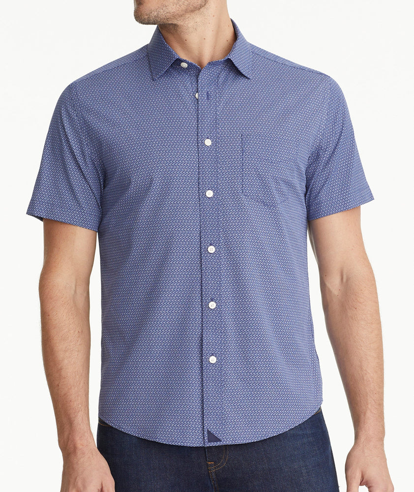 Model is wearing UNTUCKit Wrinkle-Free Performance Short-Sleeve Murphy Shirt in Blue With Small Geo Print. 