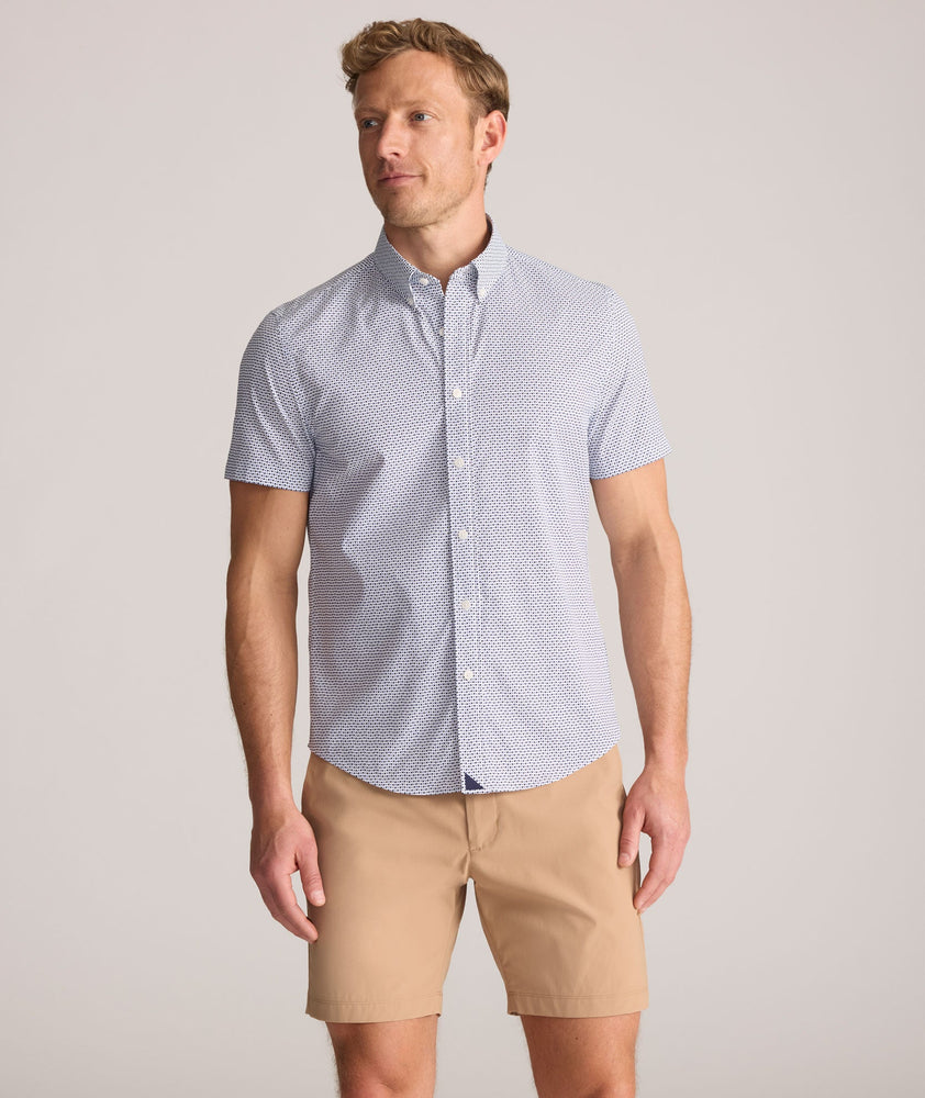 Model is wearing UNTUCKit Performance Short-Sleeve Nouveau Shirt in Navy Geo Print.