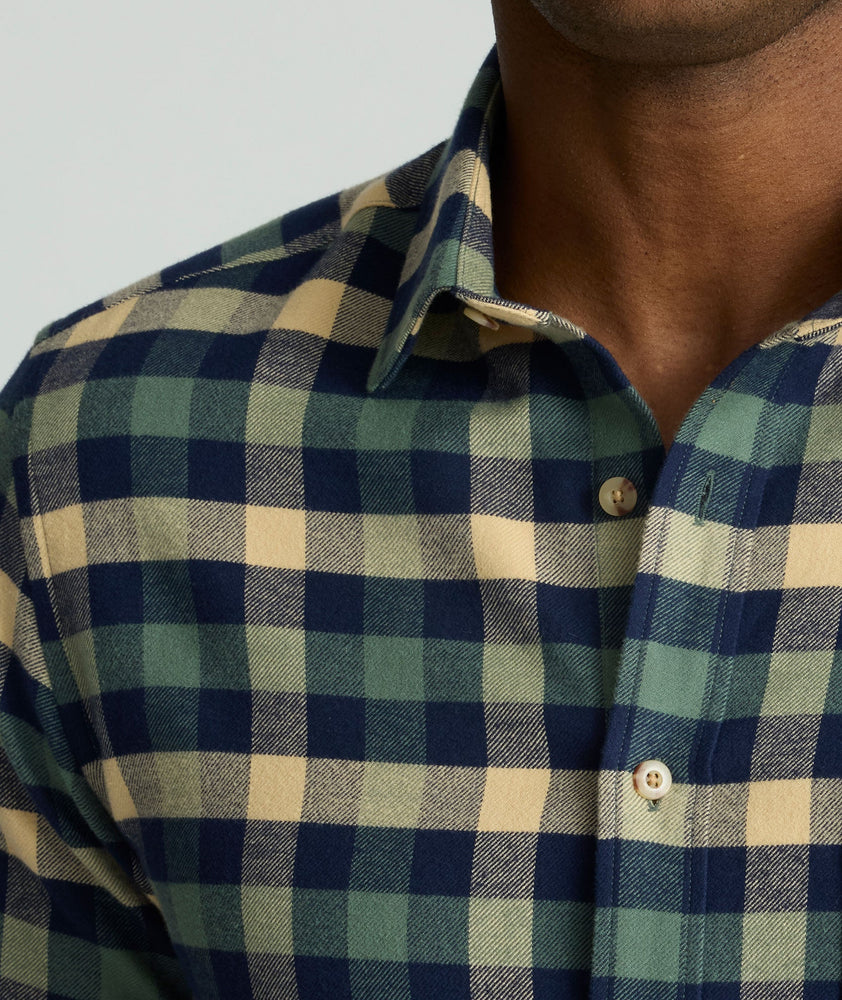 Model is wearing UNTUCKit Flannel Plenville Shirt in green check. 
