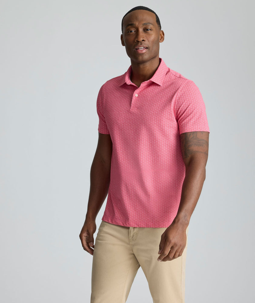 Model is wearing UNTUCKit Model is wearing UNTUCKit CottonTek Polo in Magenta Wine Bottle Print.