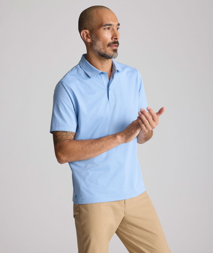 Model is wearing UNTUCKit Textured Performance Polo in blue. 