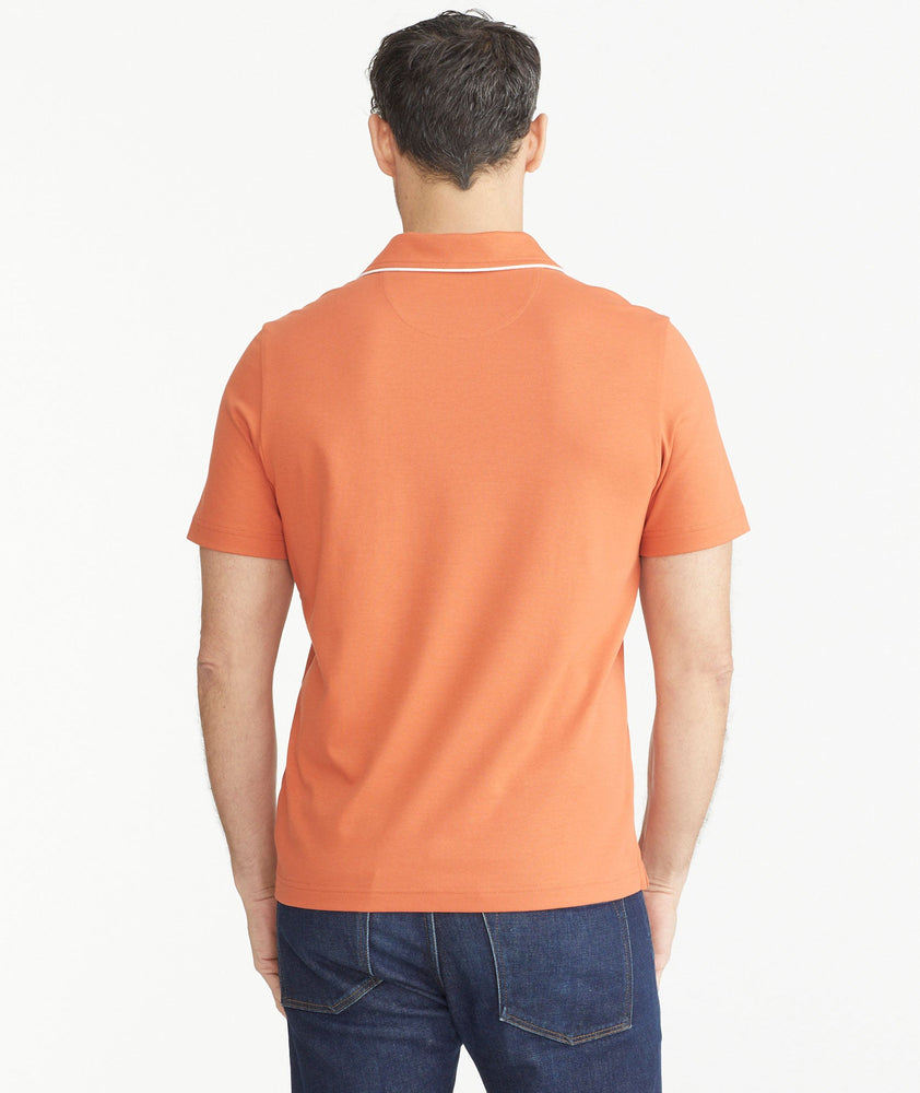 Model is wearing UNTUCKit orange Tipped Johnny Collar Polo.