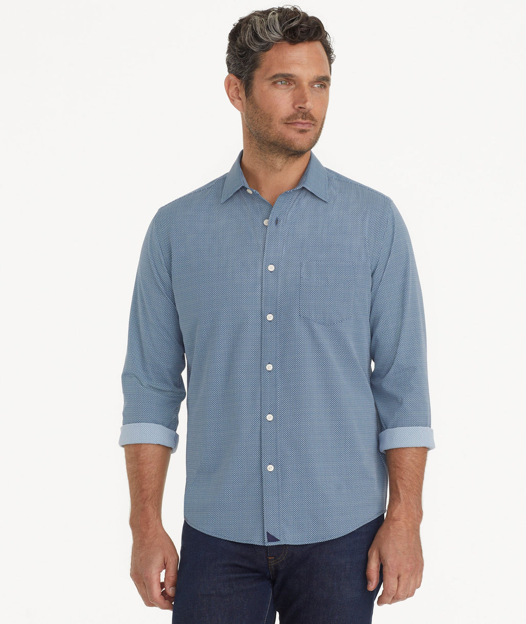 Model is wearing UNTUCKit Wrinkle-Free Performance Benny Shirt in Navy Grounded Gold & White Dot Print.