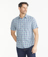 Model is wearing UNTUCKit Navy & Teal Check Wrinkle-Free Performance Short-Sleeve Henderson Shirt.